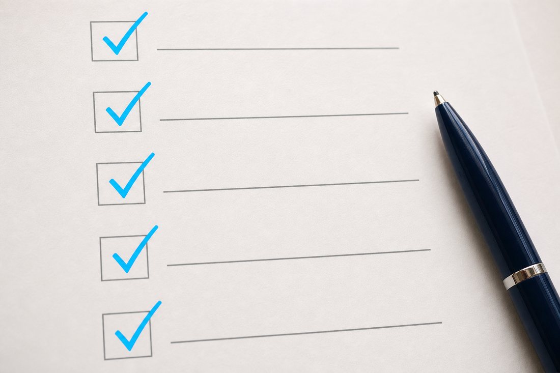 A printed checklist with every line ticked, beside a pen